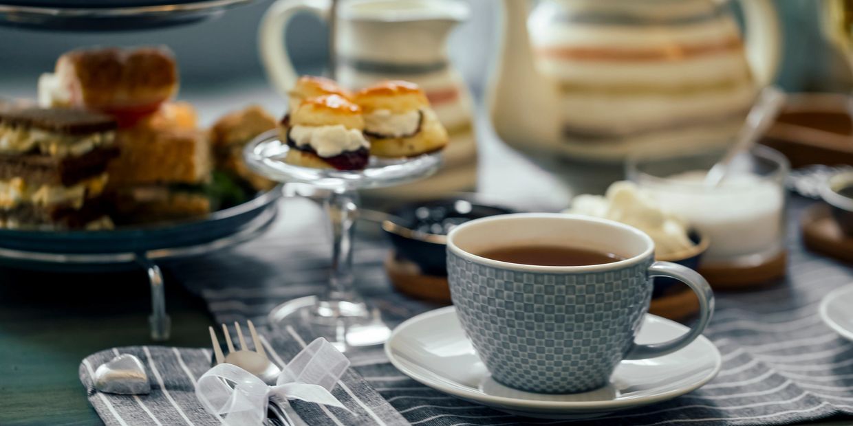 Elegant tea setup with a cup of tea and assorted pastries.