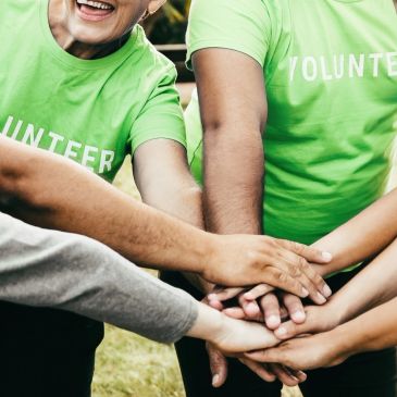 Volunteers joining hands in unity.