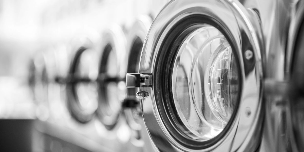 Close-up of washing machine doors in a row.