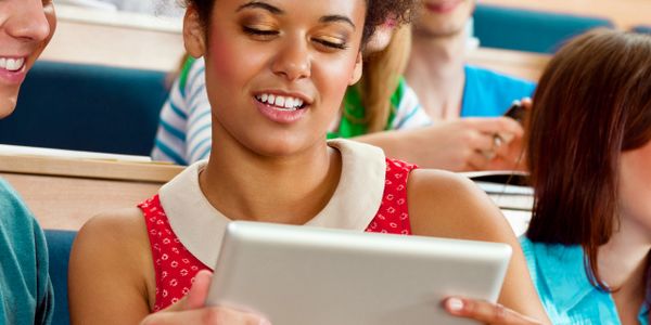 Young woman using a tablet in a classroom setting.