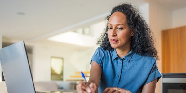 Clinician writing notes at a laptop
