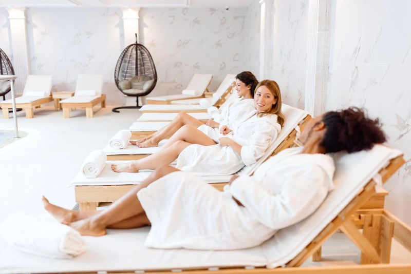 Multiracial female friends relaxing next to the pool in the hotel