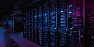 A dimly lit server room with rows of illuminated racks.