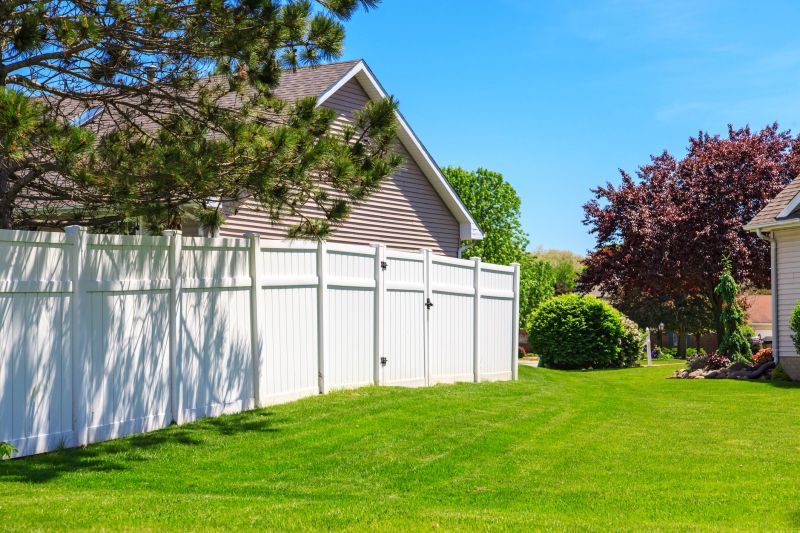White vinyl fence enclosing a backyard.
