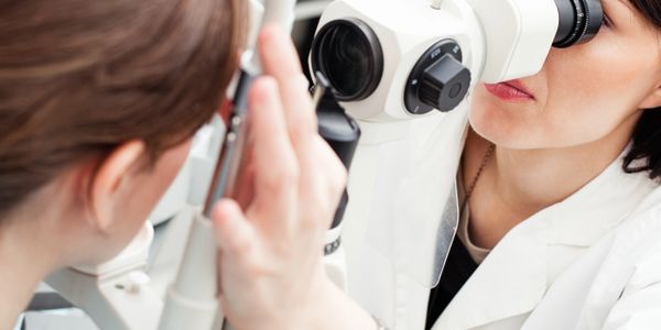 An eye doctor conducts an eye examination using specialized equipment.