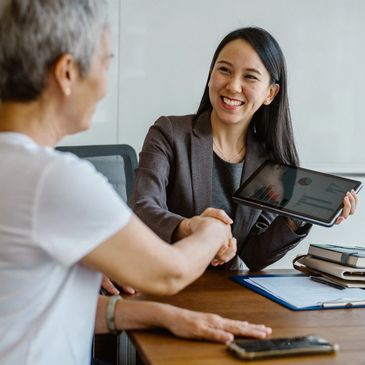 Four coworkers enthusiastically giving a group high-five in an office.