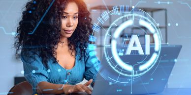 Woman working on laptop with futuristic AI interface overlay.