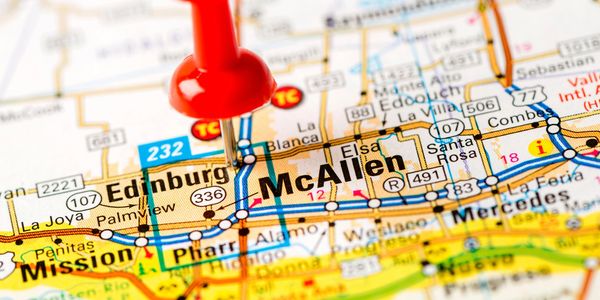 Red pushpin marking McAllen on a map with surrounding cities.