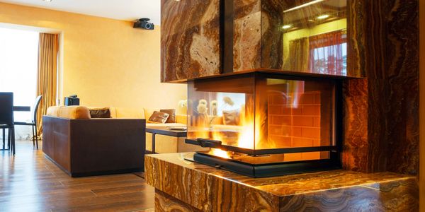 Modern living room with a luxurious marble fireplace and warm lighting.