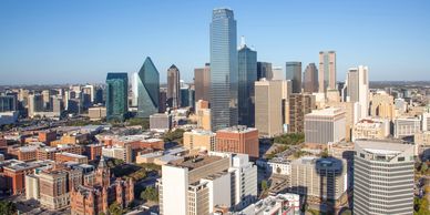 A clear daytime view of a modern city skyline with diverse skyscrapers.