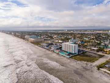 Aerial view of a coastal city with beachfront buildings.