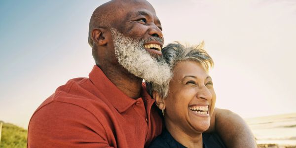 Happy senior couple embracing outdoors, enjoying a sunny day.