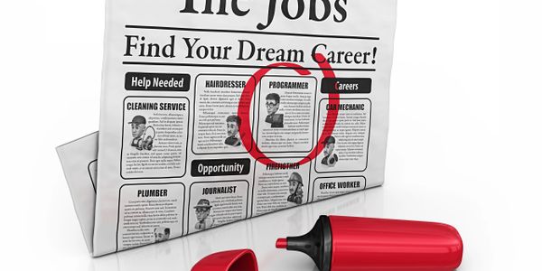 Newspaper job ads with programmer circled and red marker.