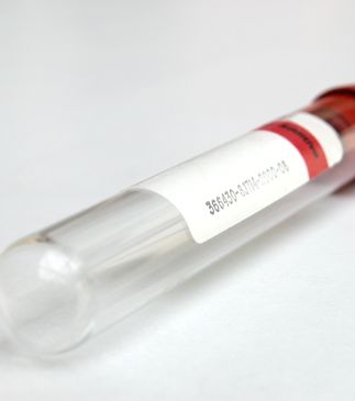 Empty test tube with a red cap and a label on it.