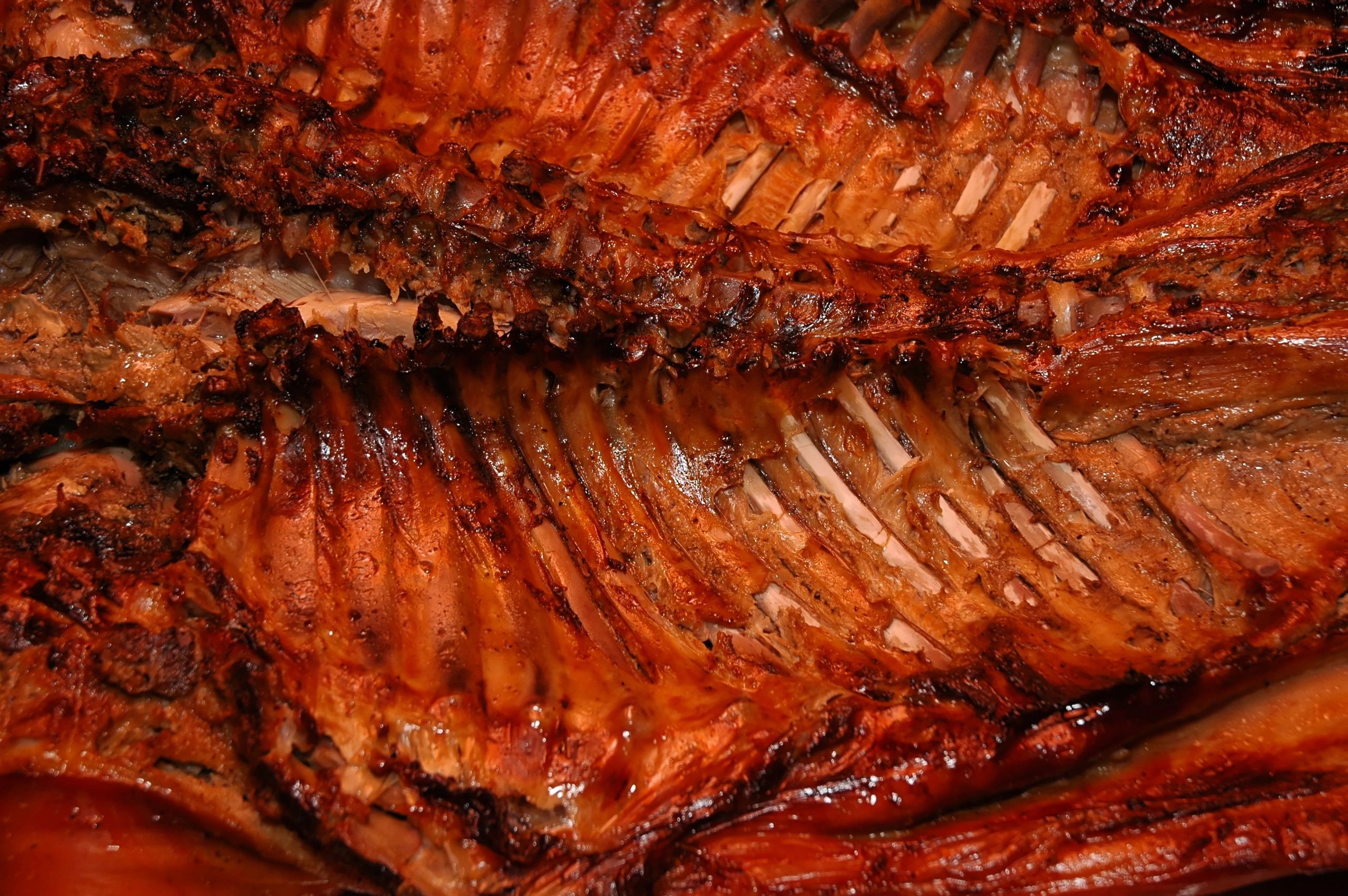 Close-up of grilled ribs with charred, crispy edges.