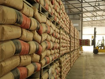 Depoda paletler üzerinde istiflenmiş torbalar ve forklift.