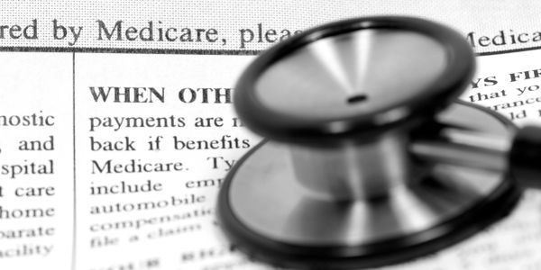 Stethoscope resting on Medicare document.