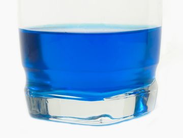 Close-up of a glass with blue liquid.