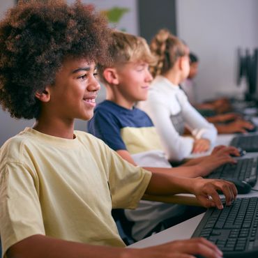 Students engaged in a computer class, focused and typing.
