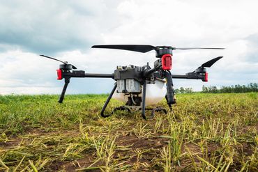 Agricultural drone resting on a field ready for crop monitoring.
