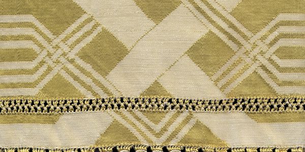 Close-up of a gold and cream woven textile with geometric patterns.