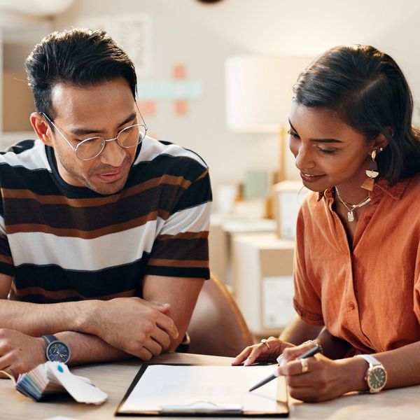 Two people discussing paperwork at a table.