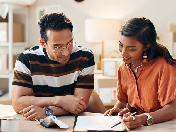 Two people reviewing documents together at a table in a cozy office.