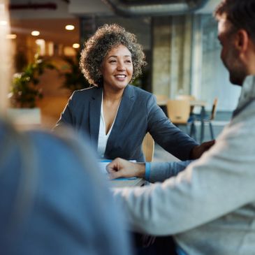 Woman smiling during a meeting with colleagues.