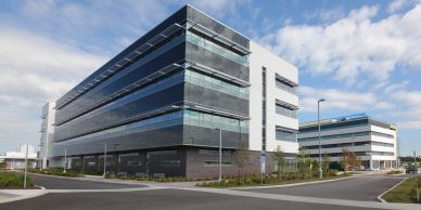 Modern office buildings under a partly cloudy sky.
