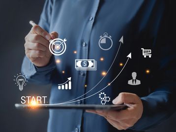 Businessman using tablet with growth and success icons floating above.