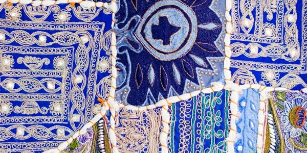 Close-up of a blue and white embroidered textile with intricate patterns.
