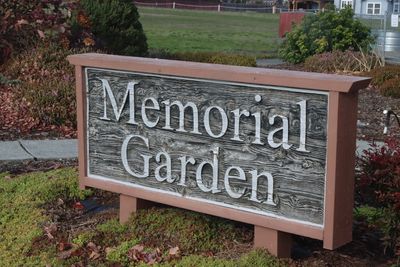 Wooden sign reading 'Memorial Garden' in a landscaped area.