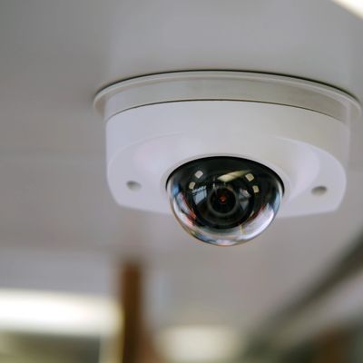 Ceiling-mounted dome security camera with a clear protective cover.