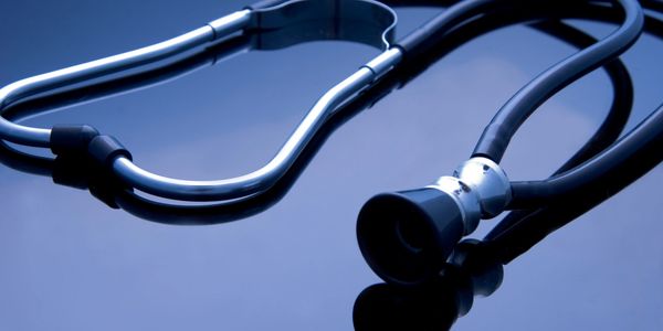 Close-up of a stethoscope on a reflective surface.