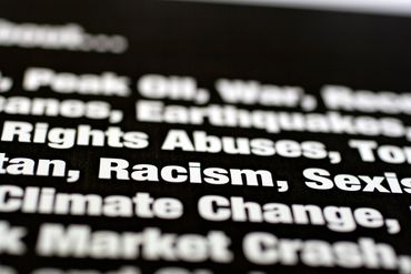 Close-up of text listing global issues like racism, sexism, and climate change.