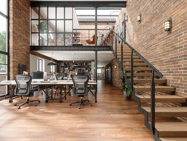 Modern industrial office with brick walls and wooden flooring.
