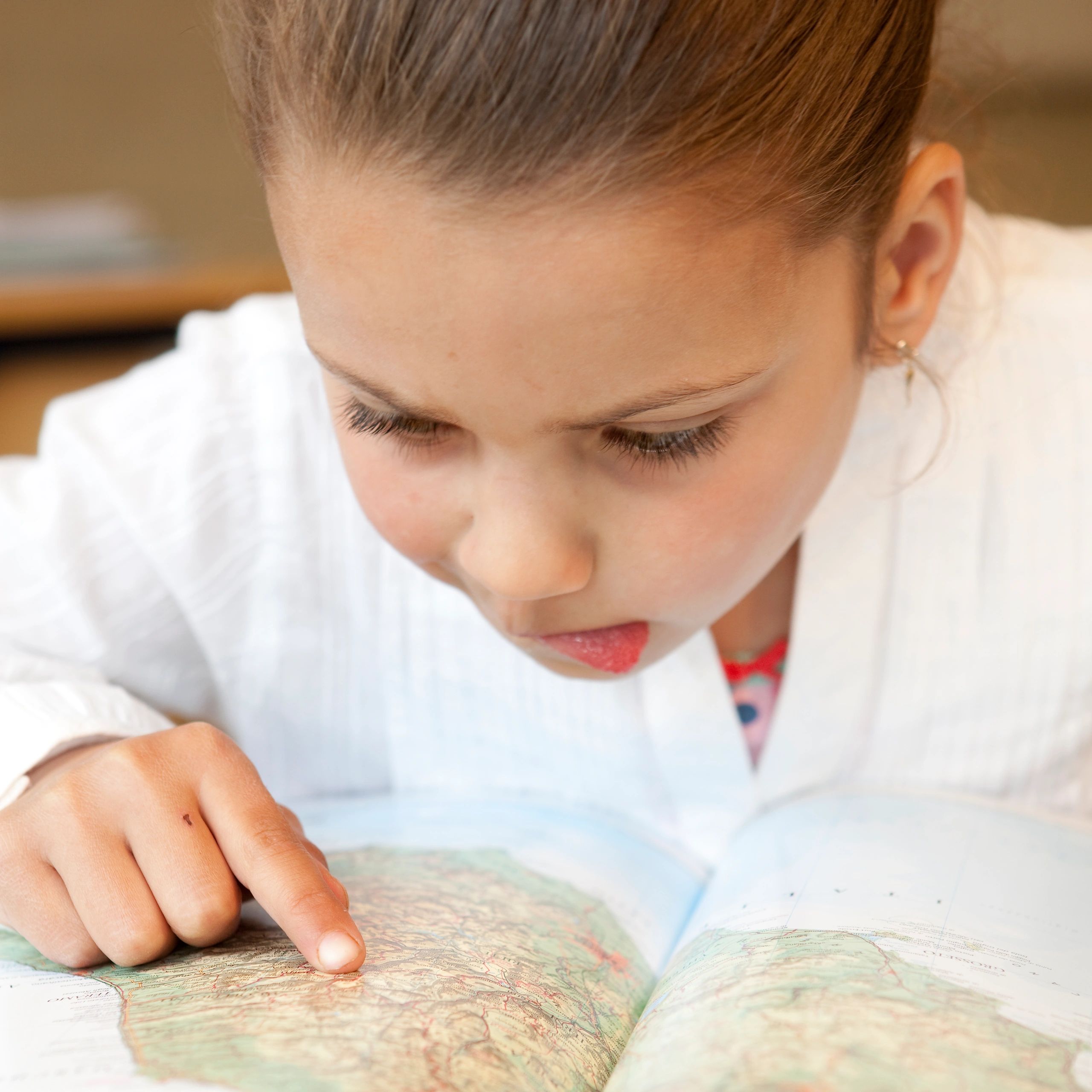 Girl reading a map intently.