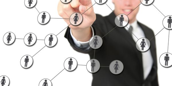 Businessman interacting with a virtual social network of male and female icons. He is providing event staffing support. 