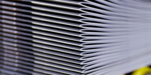 Stack of folded newspapers on a white background.