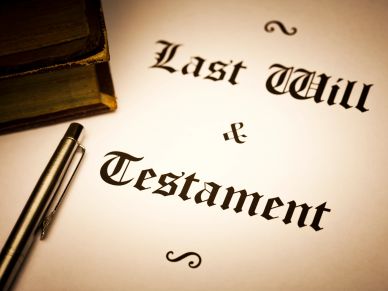 Document titled "Last Will &amp; Testament" with a pen and book.