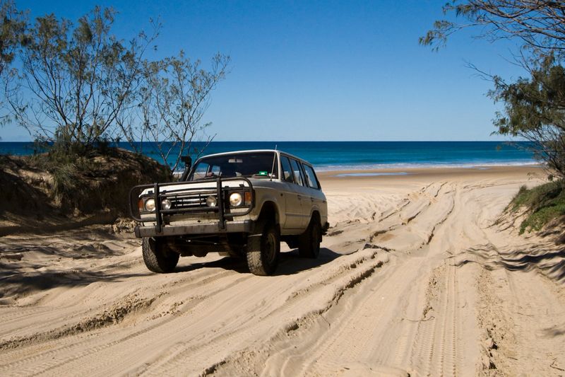 A 4WD tackling the sandy track around Indian Head on Fraser Island in Queensland.