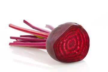 Fresh beetroot with vibrant red and purple hues on a white background.
