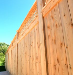 Tall wooden fence under clear blue sky.