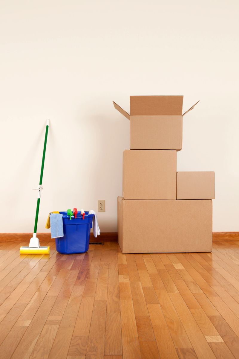 Cleaning and moving supplies. Cardboard boxes and a mop in an empty room.Please also see: