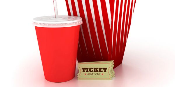 Red drink cup, popcorn container, and movie ticket on white background.