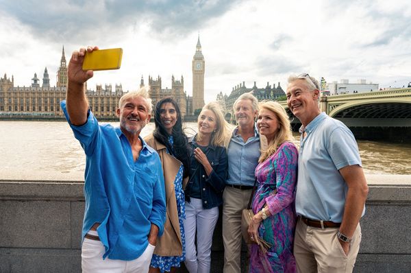 Group of travelers taking a selfie with Big Ben in London in the background.