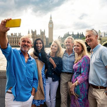 Group of six tourists taking a selfie near Big Ben in London.