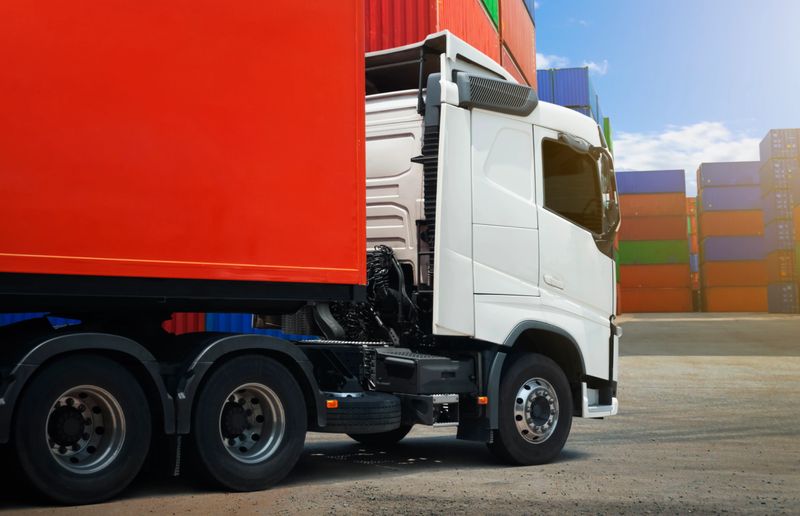 Semi trailer Trucks on The Parking Lot at Port. Containers Cargo Shipping. Handling of Logistics Transportation Industry. Cargo Container ships, Freight Trucks Import-Export. Distribution Warehouse.