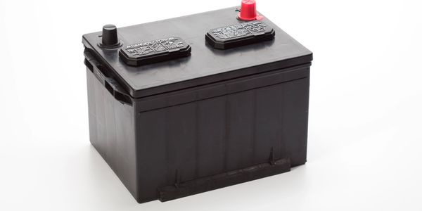 Black car battery with red and black terminals.