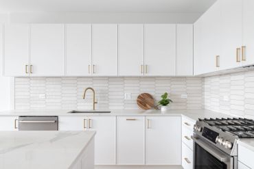 Modern white kitchen with gold fixtures.